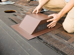Installing Attic Vent on Home Roof Replacement Project