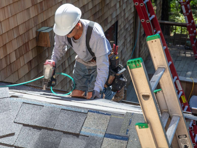 Man installing asphalt roof tiles
