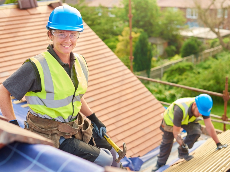 female roofer replacing roof tiles