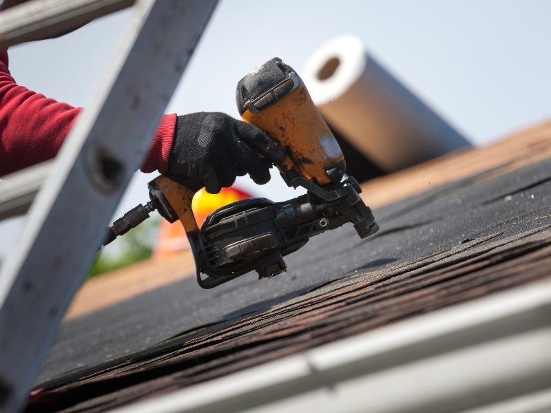roofers installing new asphalt roof on house
